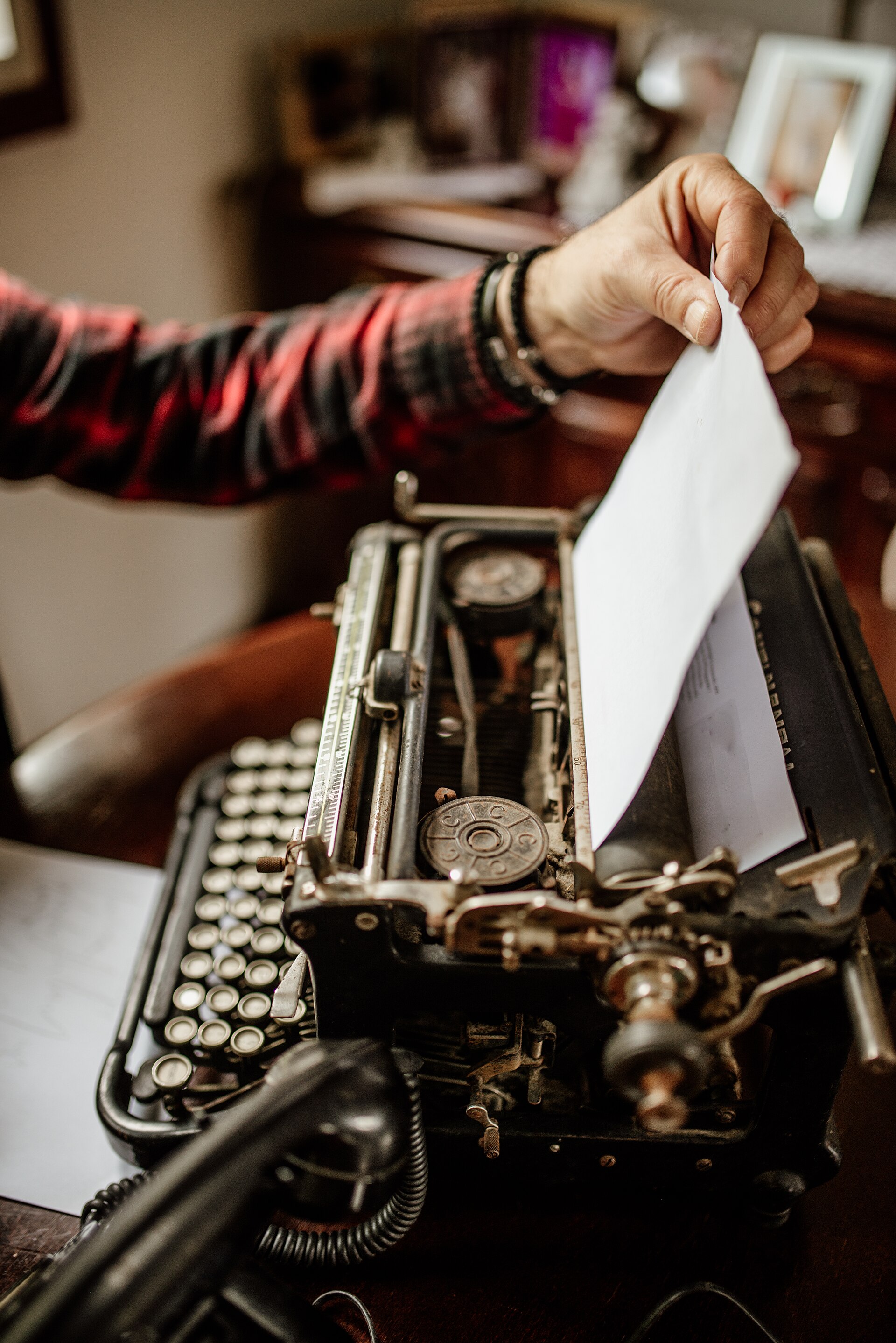 Une main engage une feuille blanche dans une machine à écrire ancienne — rédiger un texte articulé au niveau B2