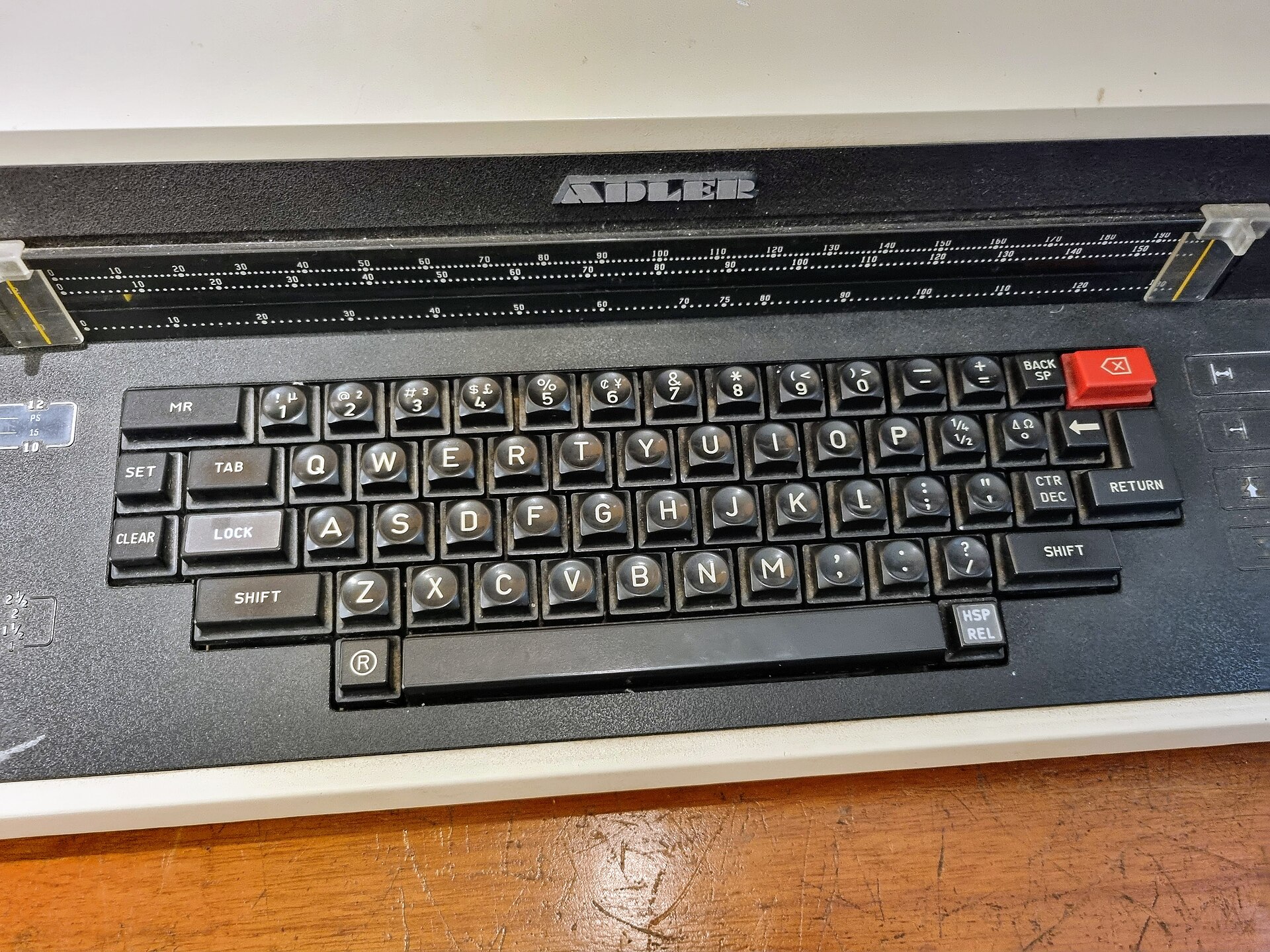 Le clavier d'une machine à écrire vu de près, touches alignées rangée par rangée — l'ordre des pronoms COD, COI, en et y
