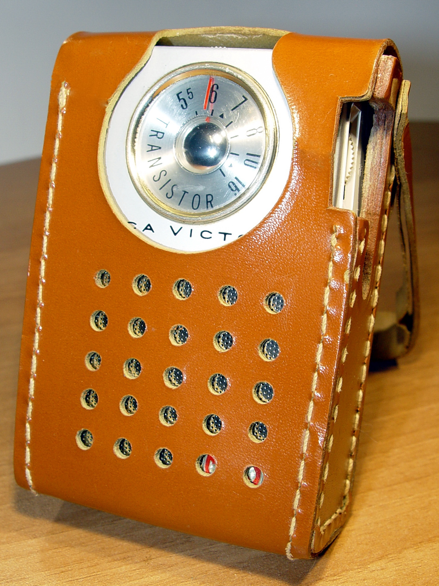 Un petit poste de radio portatif dans son étui de cuir, molette de fréquence en évidence — écouter du français au quotidien
