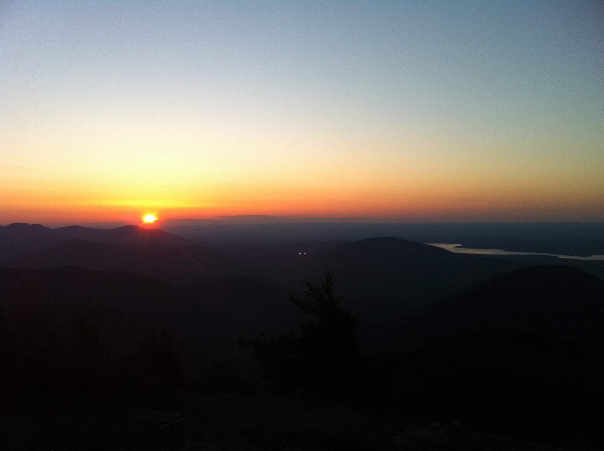 Lever de soleil vu depuis un sommet, crêtes de montagnes en enfilade — franchir le palier du NCLC 7