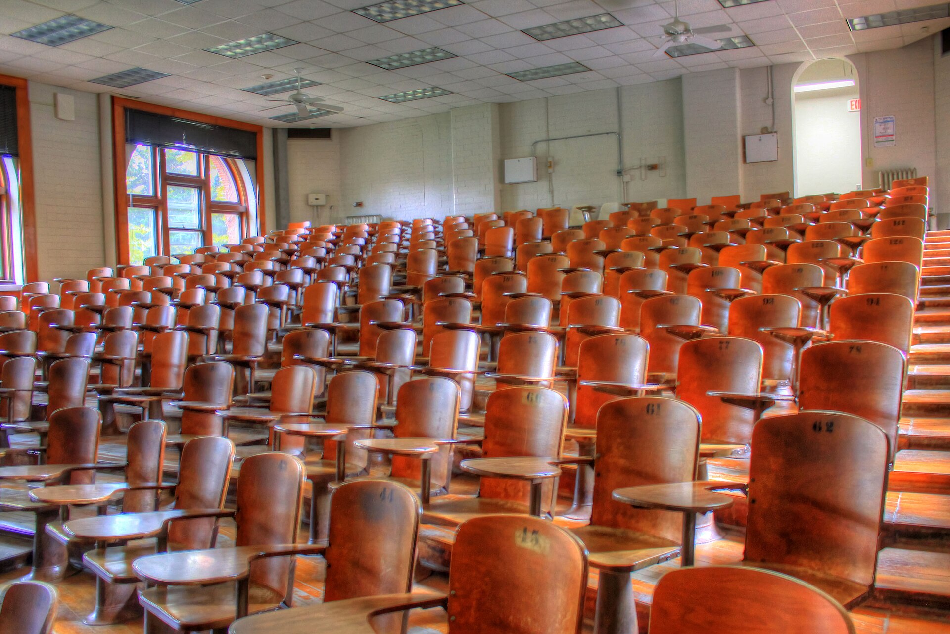 Amphithéâtre universitaire vide aux sièges numérotés — salle d'examen avant une session du TCF Canada