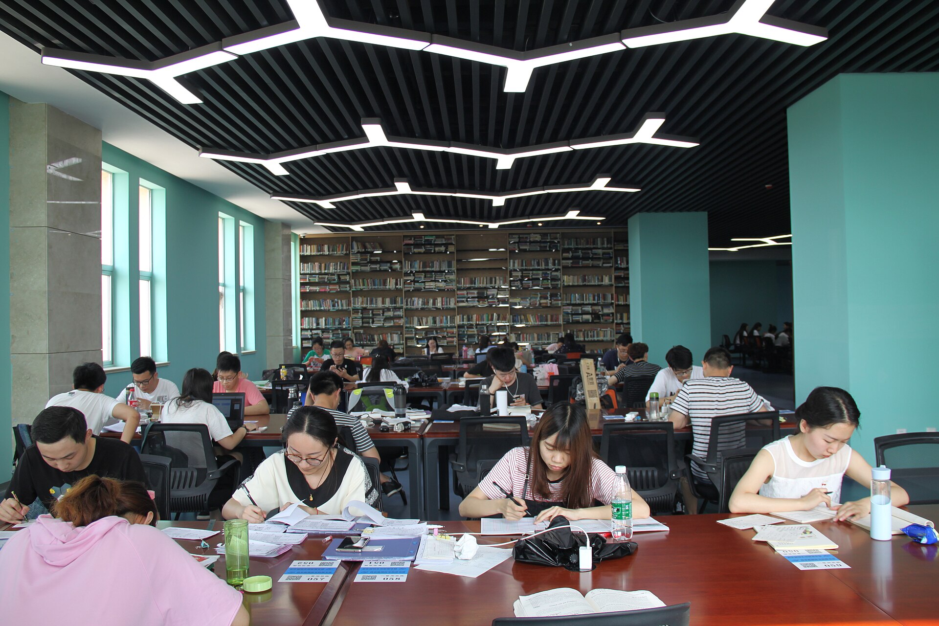 Étudiants qui révisent à de longues tables dans une bibliothèque universitaire — préparer une seconde tentative au TCF Canada