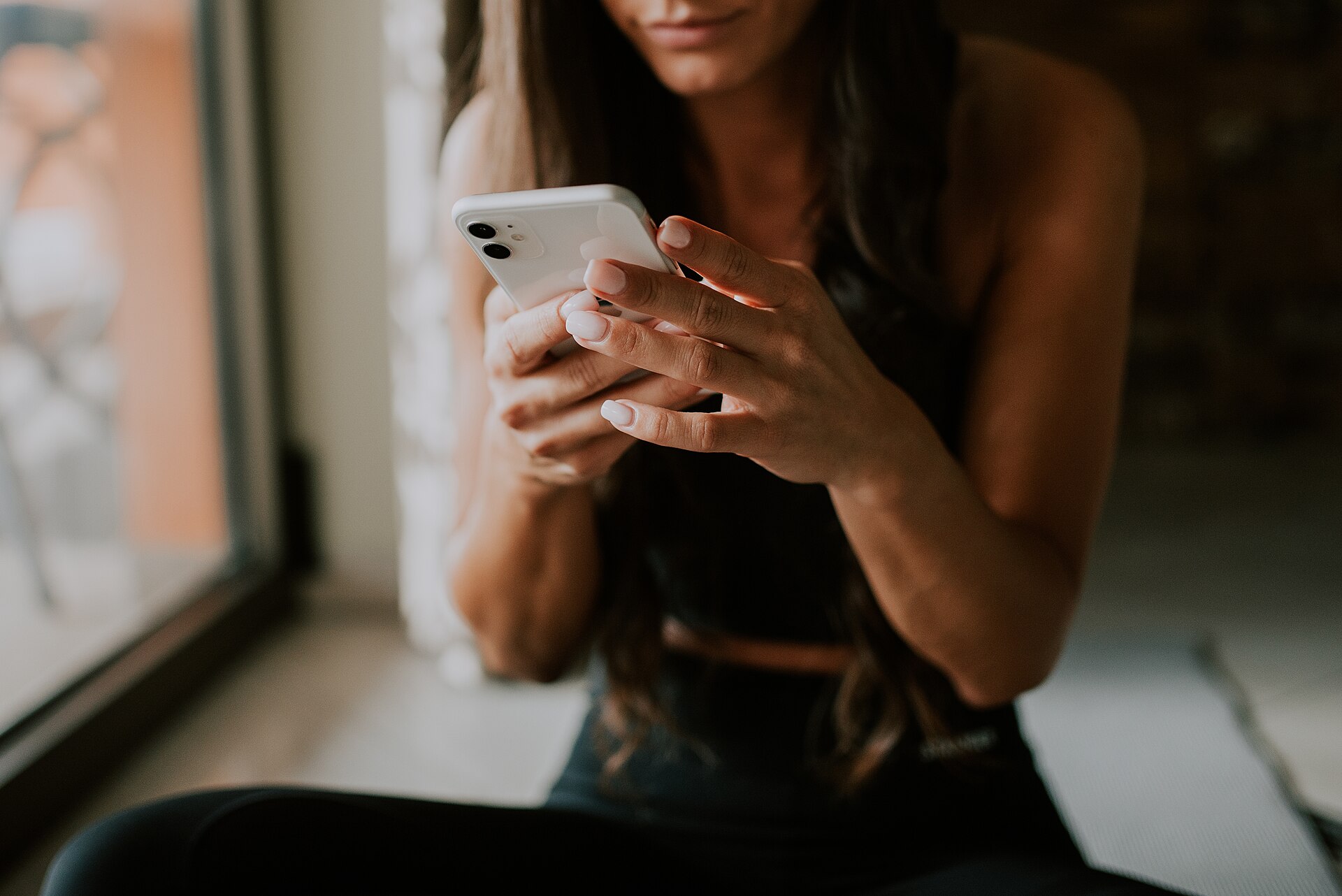 Personne consultant son téléphone tenu à deux mains — attente des résultats du TCF Canada